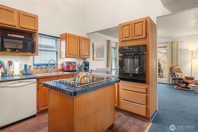 kitchen featuring dark wood-style flooring, a kitchen island, a sink, tile counters, and black appliances