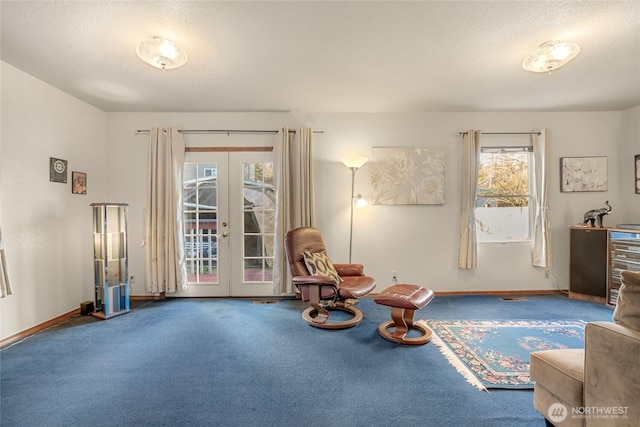 sitting room with carpet floors, baseboards, a textured ceiling, and french doors