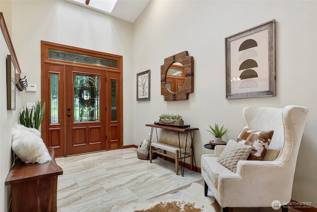 foyer entrance with a skylight and a towering ceiling