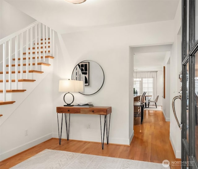 entrance foyer with stairs, wood finished floors, and baseboards