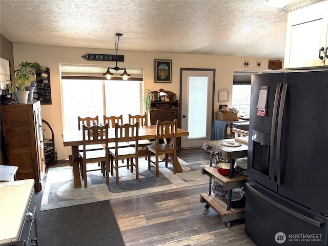 dining space with dark wood-style floors and a textured ceiling