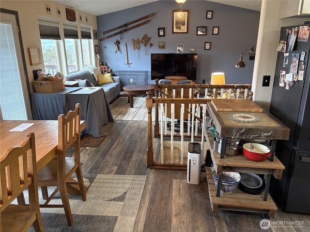 dining room featuring dark wood-style floors and lofted ceiling