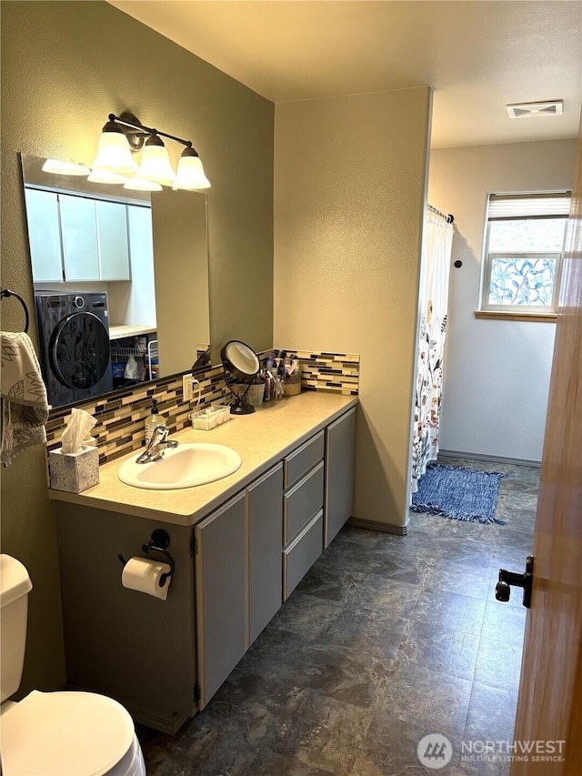 full bathroom with washer / clothes dryer, visible vents, toilet, and decorative backsplash