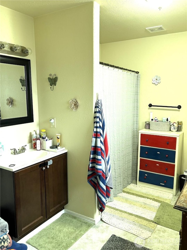 full bathroom featuring vanity, visible vents, and baseboards