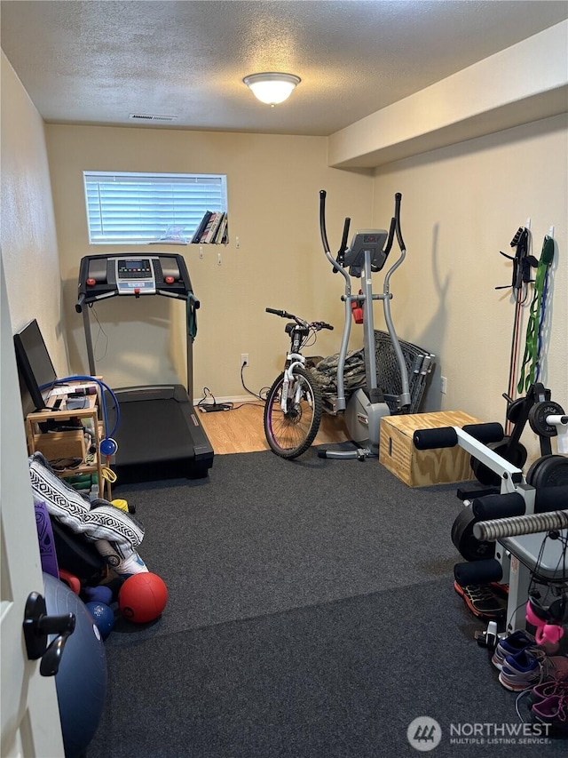 workout room featuring visible vents and a textured ceiling