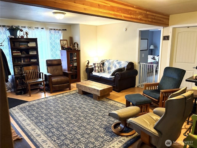 living room featuring beam ceiling and light wood finished floors