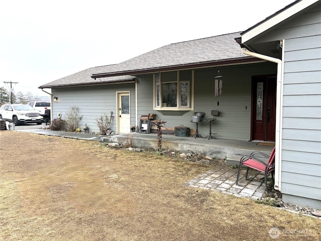 rear view of property with a shingled roof