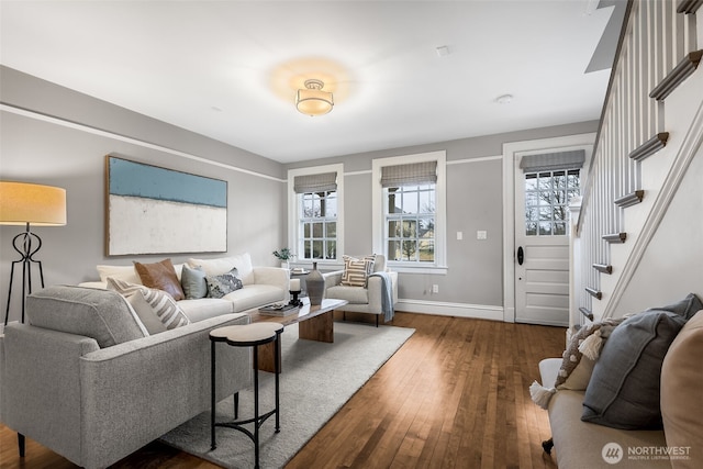 living room featuring plenty of natural light, stairway, dark wood finished floors, and baseboards