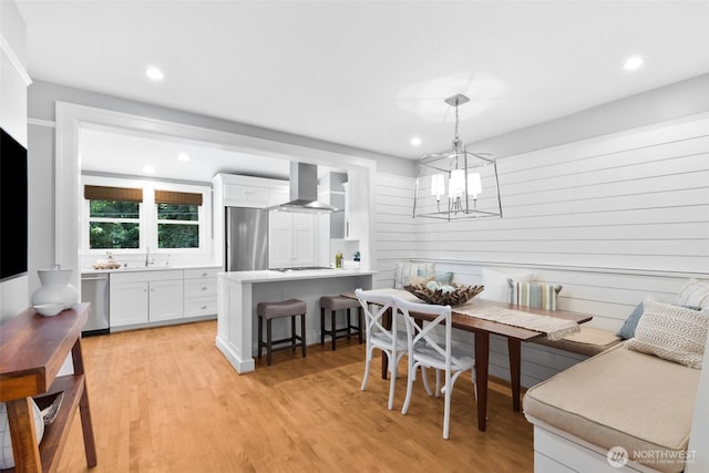 dining space featuring light wood-style floors, recessed lighting, breakfast area, and an inviting chandelier