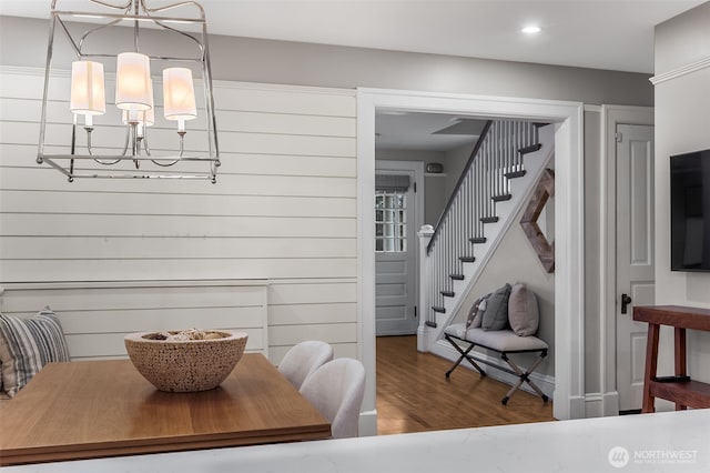 dining space featuring recessed lighting, stairs, a notable chandelier, and wood finished floors