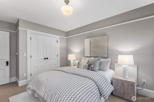 bedroom featuring baseboards, a closet, and light colored carpet