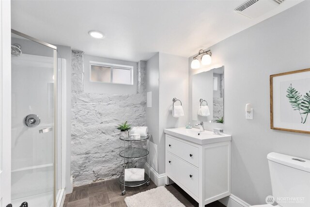 full bathroom featuring visible vents, toilet, a stall shower, and vanity