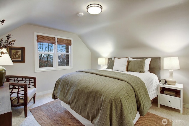 bedroom featuring lofted ceiling, light carpet, and baseboards