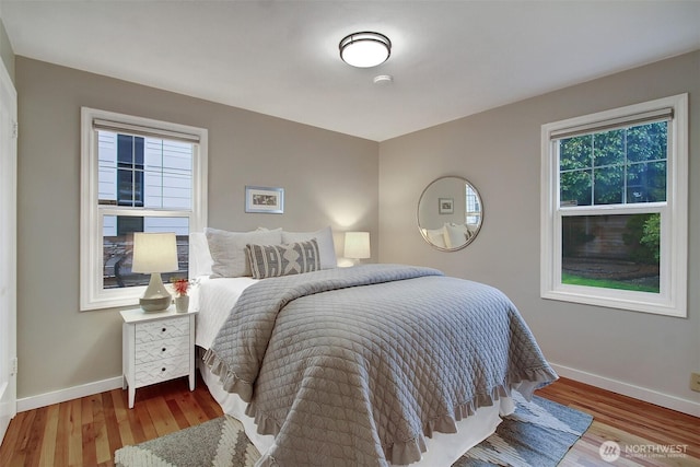 bedroom featuring baseboards and light wood finished floors