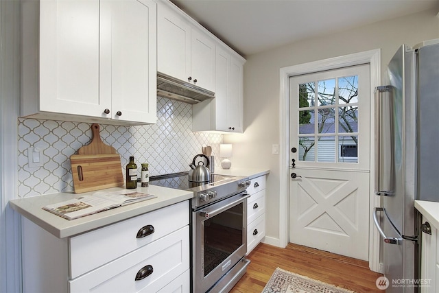 kitchen featuring appliances with stainless steel finishes, white cabinetry, under cabinet range hood, and light wood finished floors