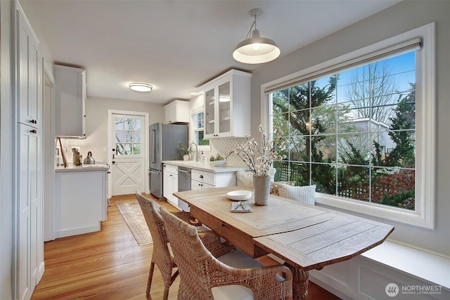 dining area with light wood-style flooring and a healthy amount of sunlight