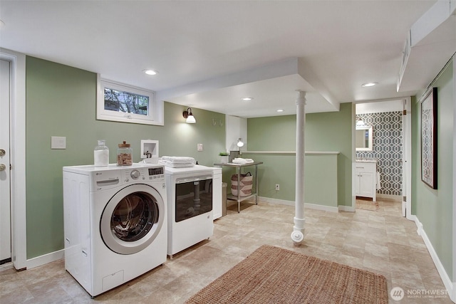 washroom featuring laundry area, washing machine and clothes dryer, and baseboards