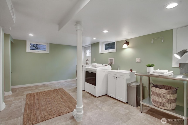 laundry room featuring cabinet space, baseboards, washing machine and dryer, a sink, and recessed lighting