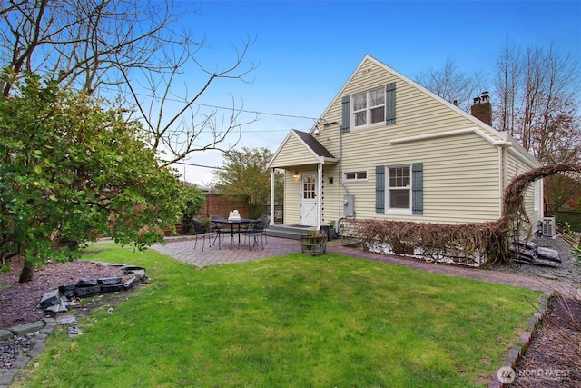 back of house featuring a yard, fence, a chimney, and central AC unit