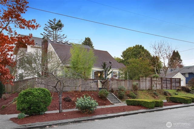 view of front of house with roof with shingles and a fenced front yard