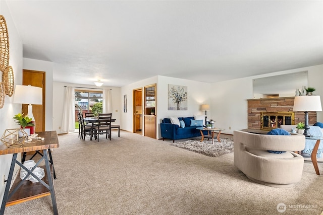 carpeted living room with a stone fireplace