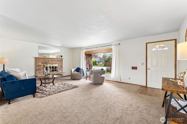 carpeted living room featuring a fireplace and baseboards