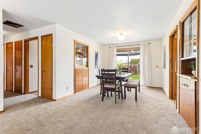 carpeted dining room featuring visible vents and baseboards