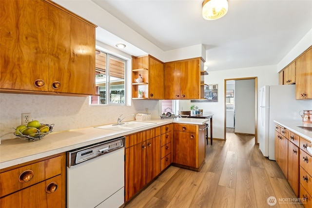 kitchen featuring white appliances, open shelves, a sink, light countertops, and light wood-type flooring