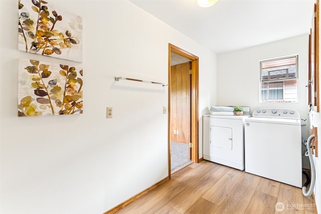 laundry room with laundry area, baseboards, light wood-type flooring, and washing machine and clothes dryer