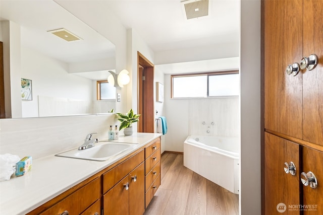 bathroom with visible vents, plenty of natural light, and wood finished floors