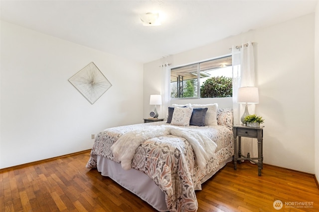 bedroom with baseboards and hardwood / wood-style floors