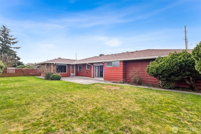 rear view of house with a patio area, a lawn, and fence