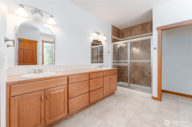 full bathroom featuring double vanity, a shower stall, and a sink