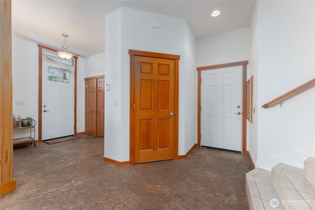 entryway featuring baseboards, concrete flooring, and recessed lighting