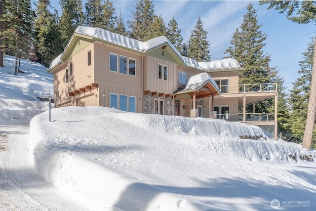 view of front facade featuring stone siding, board and batten siding, and an attached garage