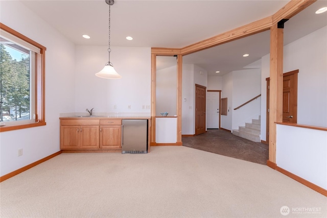 interior space featuring recessed lighting, light colored carpet, a sink, baseboards, and stairs