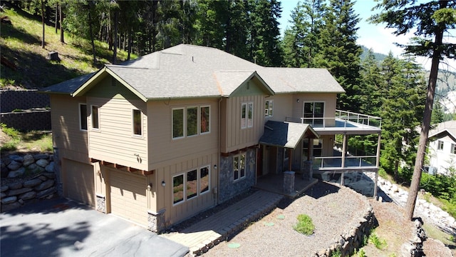 6760 Forest Ridge Dr, Wenatchee, WA 98801 - view of front of house featuring board and batten siding, roof with shingles, a garage, and stone siding