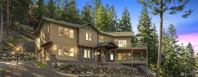 6760 Forest Ridge Dr, Wenatchee, WA 98801 - view of front of home with driveway, stone siding, a balcony, an attached garage, and board and batten siding