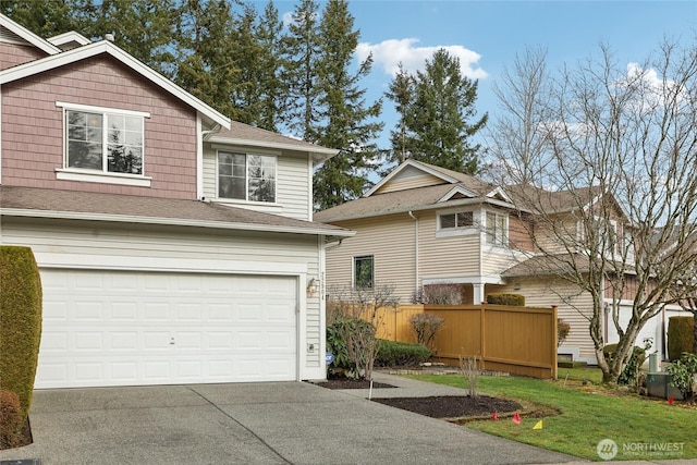 view of front of house featuring driveway, an attached garage, and fence