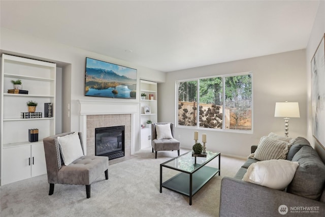 living room featuring carpet, a tiled fireplace, and built in features