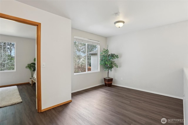 unfurnished room featuring dark wood-style floors and baseboards