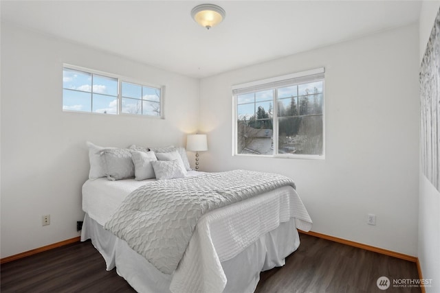 bedroom featuring multiple windows, baseboards, and wood finished floors