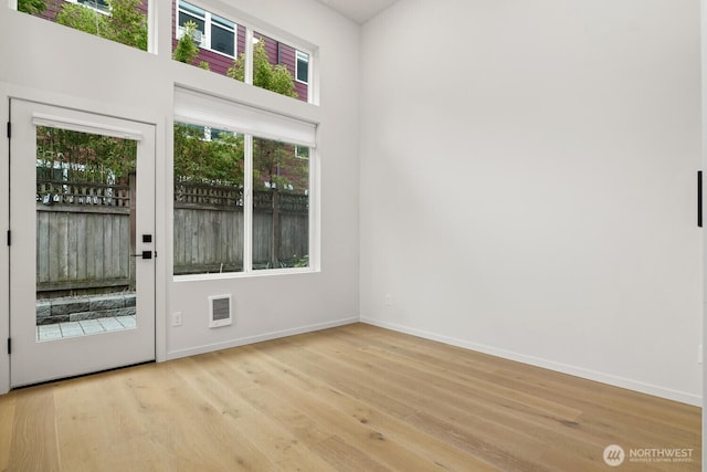 interior space featuring light wood-style floors, visible vents, and baseboards