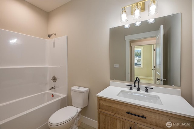 bathroom with baseboards, toilet, vanity, and  shower combination