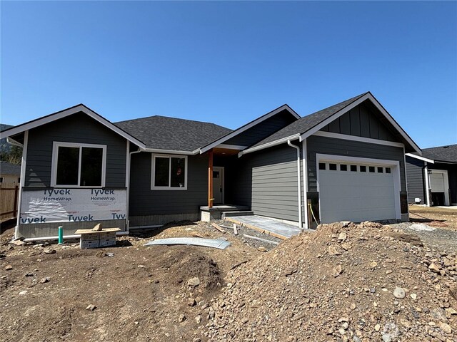 view of front of house with an attached garage, board and batten siding, and a shingled roof