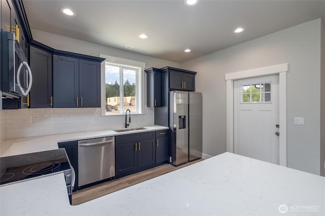 6511 Watson Loop, Maple Falls, WA 98266 - kitchen featuring appliances with stainless steel finishes, a sink, light wood-style floors, decorative backsplash, and recessed lighting