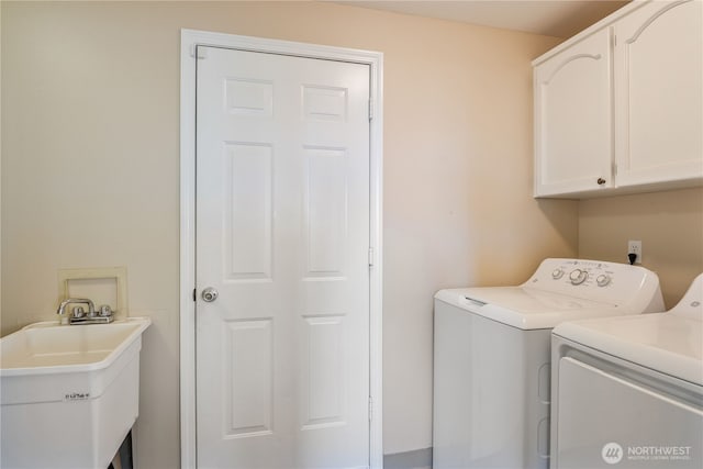 laundry room with a sink, cabinet space, and washer and clothes dryer