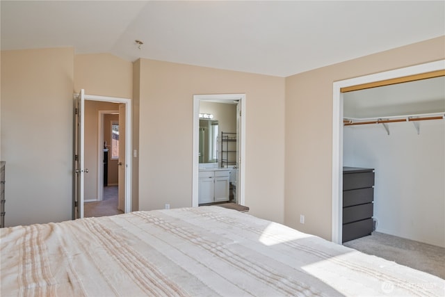 unfurnished bedroom with ensuite bath, lofted ceiling, a closet, and carpet floors