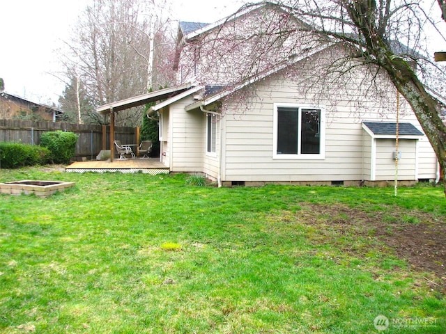 back of property featuring a wooden deck, a yard, and fence