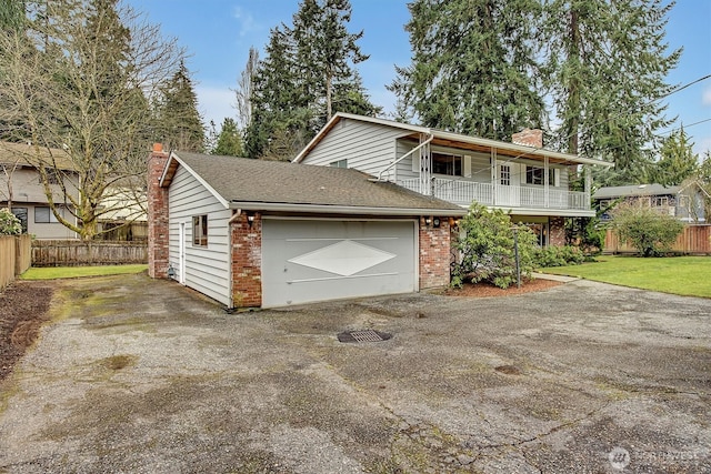 view of front of home with a front lawn, brick siding, a chimney, and driveway